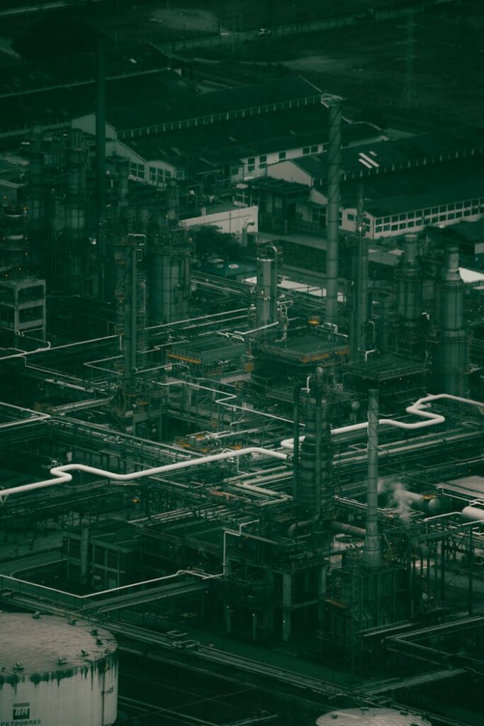 Drone shot of a large industrial power plant with pipes and machinery at dusk.